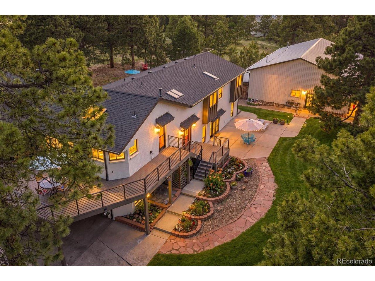 Image 1: Aerial twilight view showcasing The Tree House setting, with wraparound deck space, manicured outdoor living areas, mature pines, and the detached shop just steps from the home. Image 1: Aerial twilight view showcasing The Tree House setting, with wraparound deck space, manicured outdoor living areas, mature pines, and the detached shop just steps from the home.