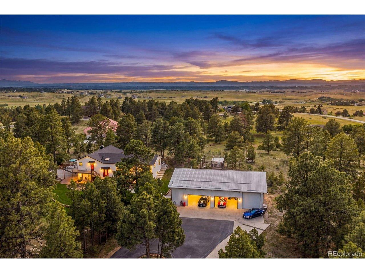Image 4: Aerial sunset view capturing the home, detached 64' x 42' shop, wooded acreage, and sweeping mountain and meadow views beyond. Image 4: Aerial sunset view capturing the home, detached 64' x 42' shop, wooded acreage, and sweeping mountain and meadow views beyond.