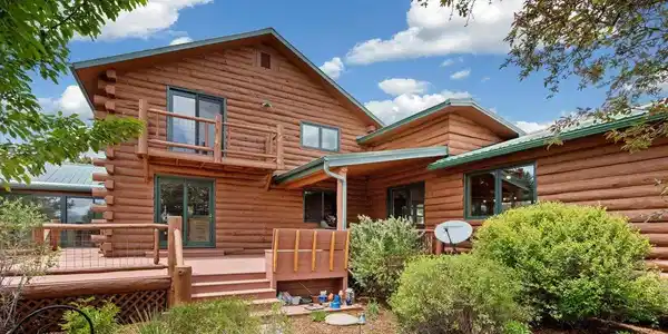 Image 3: Back deck and balcony. Balcony is off the 2nd floor Primary Suite.  Deck access from sunroom, kitchen and large family room off main level.