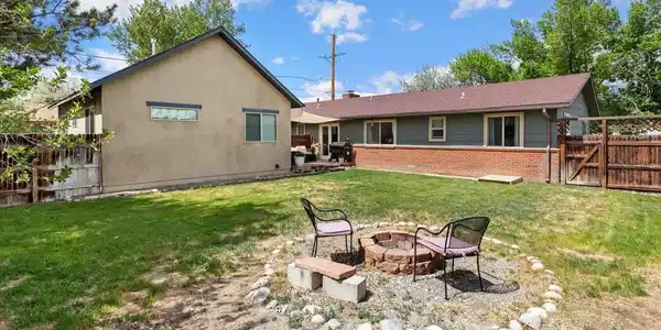 Image 4: Backyard view of the main home with private deck and large yard and fencing Image 4: Backyard view of the main home with private deck and large yard and fencing
