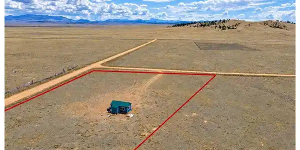 Image 2: Expansive undeveloped land featuring a small structure and distant mountain ranges under a clear sky Image 2: Expansive undeveloped land featuring a small structure and distant mountain ranges under a clear sky