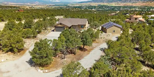 Image 2: Aerial view of the home and detached garage from the front