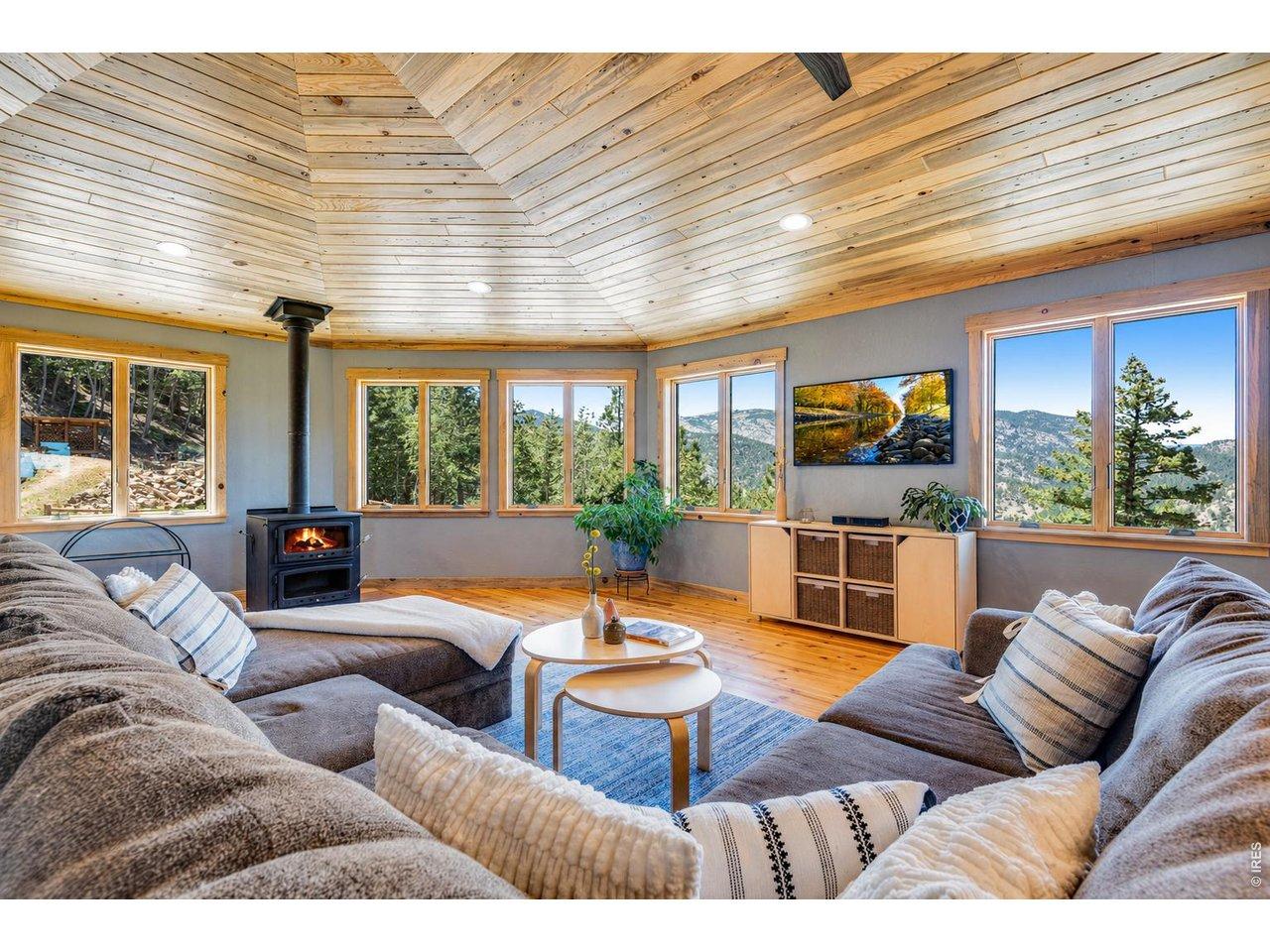Image 3: Spacious living room with vaulted wood ceilings, expansive windows, and a comfortable open layout. Image 3: Spacious living room with vaulted wood ceilings, expansive windows, and a comfortable open layout.