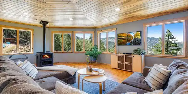 Image 3: Spacious living room with vaulted wood ceilings, expansive windows, and a comfortable open layout. Image 3: Spacious living room with vaulted wood ceilings, expansive windows, and a comfortable open layout.