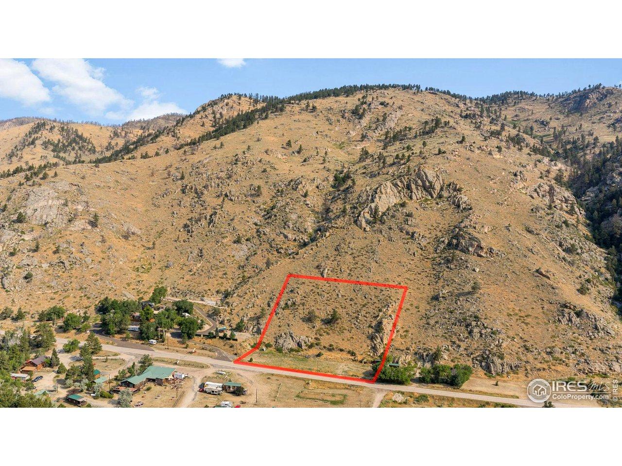 Image 2: Sweeping aerial view highlights the property's position within a striking canyon landscape surrounded by rocky ridges and pine-dotted hillsides. Image 2: Sweeping aerial view highlights the property's position within a striking canyon landscape surrounded by rocky ridges and pine-dotted hillsides.