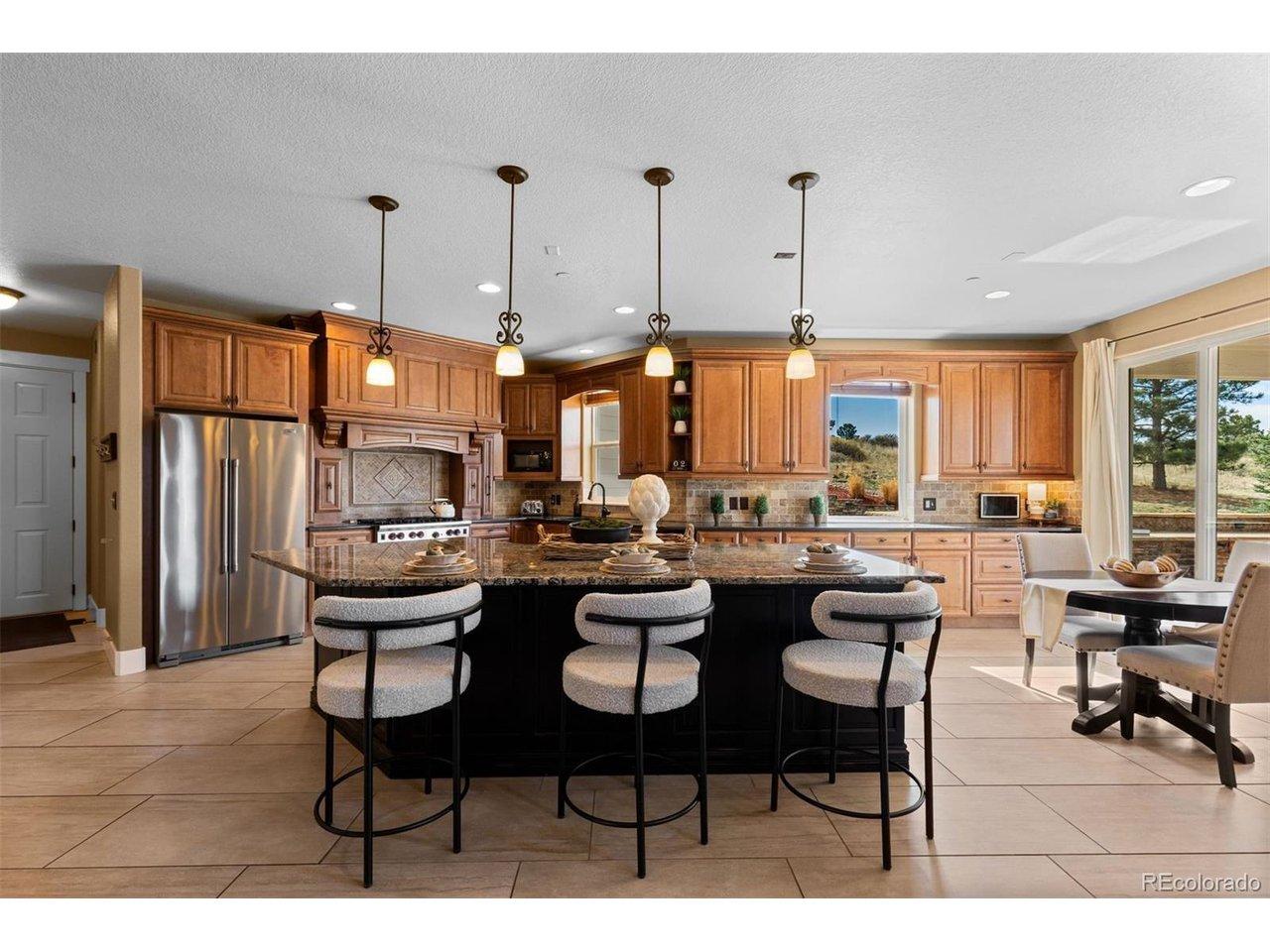 Image 3: The kitchen is beautifully appointed with granite countertops, premium appliances, and abundant storage including a spacious walk-in pantry. Image 3: The kitchen is beautifully appointed with granite countertops, premium appliances, and abundant storage including a spacious walk-in pantry.
