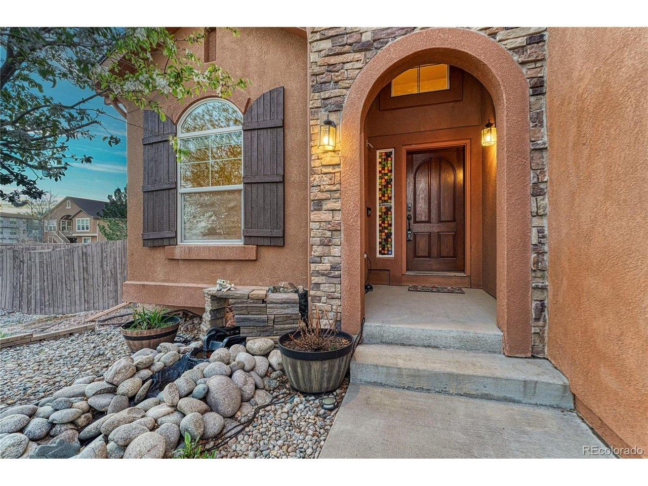 Image 3: The covered front patio area invites you into the home with warm archways and colors
