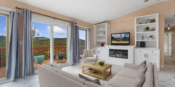 Image 3: Floor to ceiling windows/doors overlook the valley below. Built-in shelving & gas fireplace. (Furniture is virtually staged). Image 3: Floor to ceiling windows/doors overlook the valley below. Built-in shelving & gas fireplace. (Furniture is virtually staged).