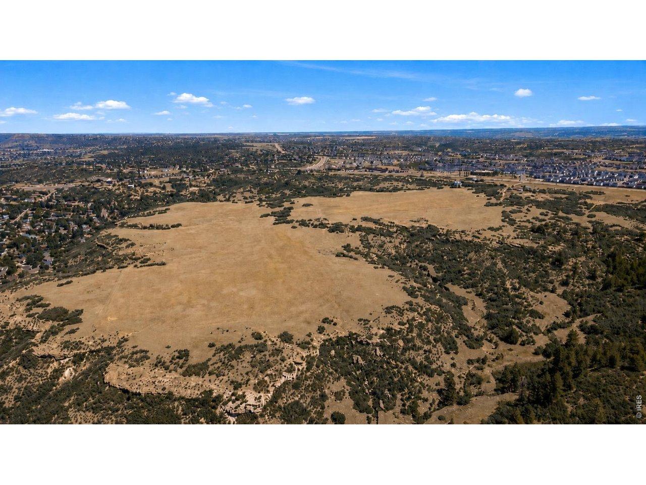 Image 2: Drone view across the gently rolling grassland, ringed by scrub oak and ponderosa pine. Open, buildable expanse with natural privacy buffers and direct adjacency to existing development. Image 2: Drone view across the gently rolling grassland, ringed by scrub oak and ponderosa pine. Open, buildable expanse with natural privacy buffers and direct adjacency to existing development.