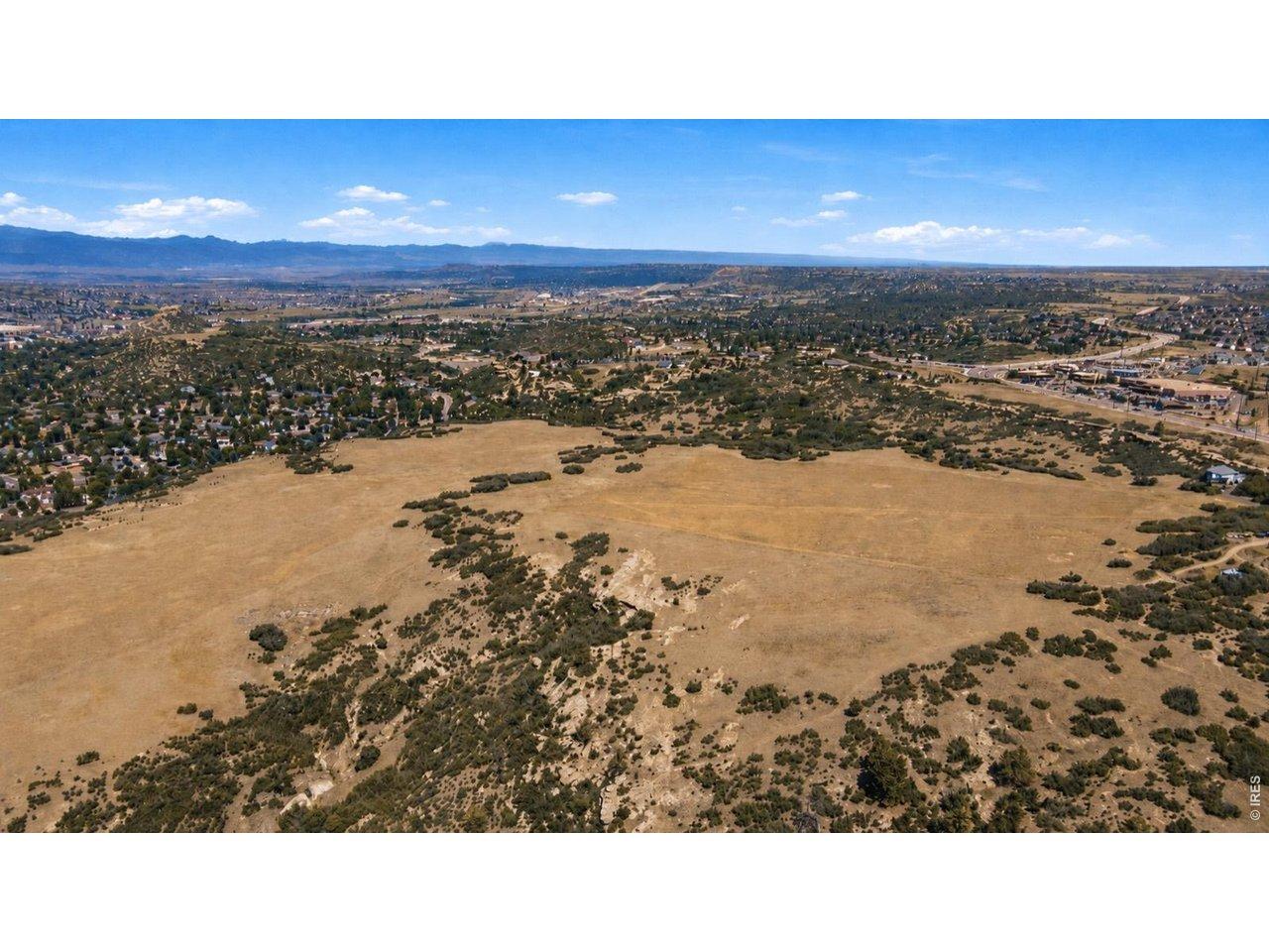 Image 4: Panoramic aerial with snow-dusted mountains beyond. The broad meadow sits minutes from town amenities yet retains an open-range character increasingly hard to find. Image 4: Panoramic aerial with snow-dusted mountains beyond. The broad meadow sits minutes from town amenities yet retains an open-range character increasingly hard to find.