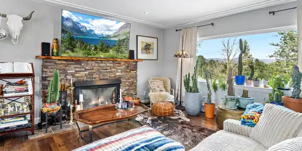 Image 4: This four-bedroom, three-bathroom property features a bright, open main-level floor plan with hickory flooring throughout