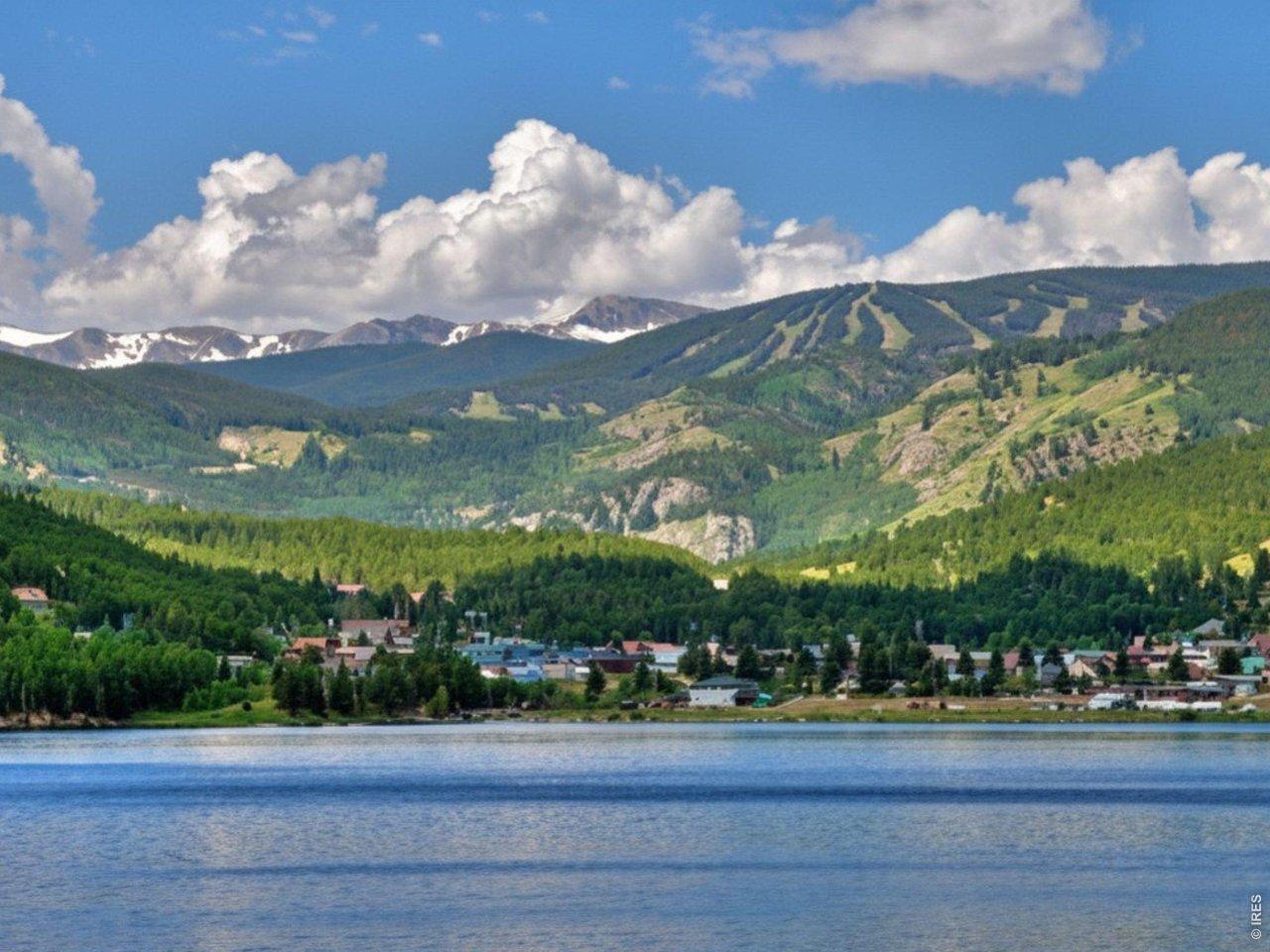 Image 3: Aerial view of nearby snow- capped mountains, lake, and blue sky. Image 3: Aerial view of nearby snow- capped mountains, lake, and blue sky.