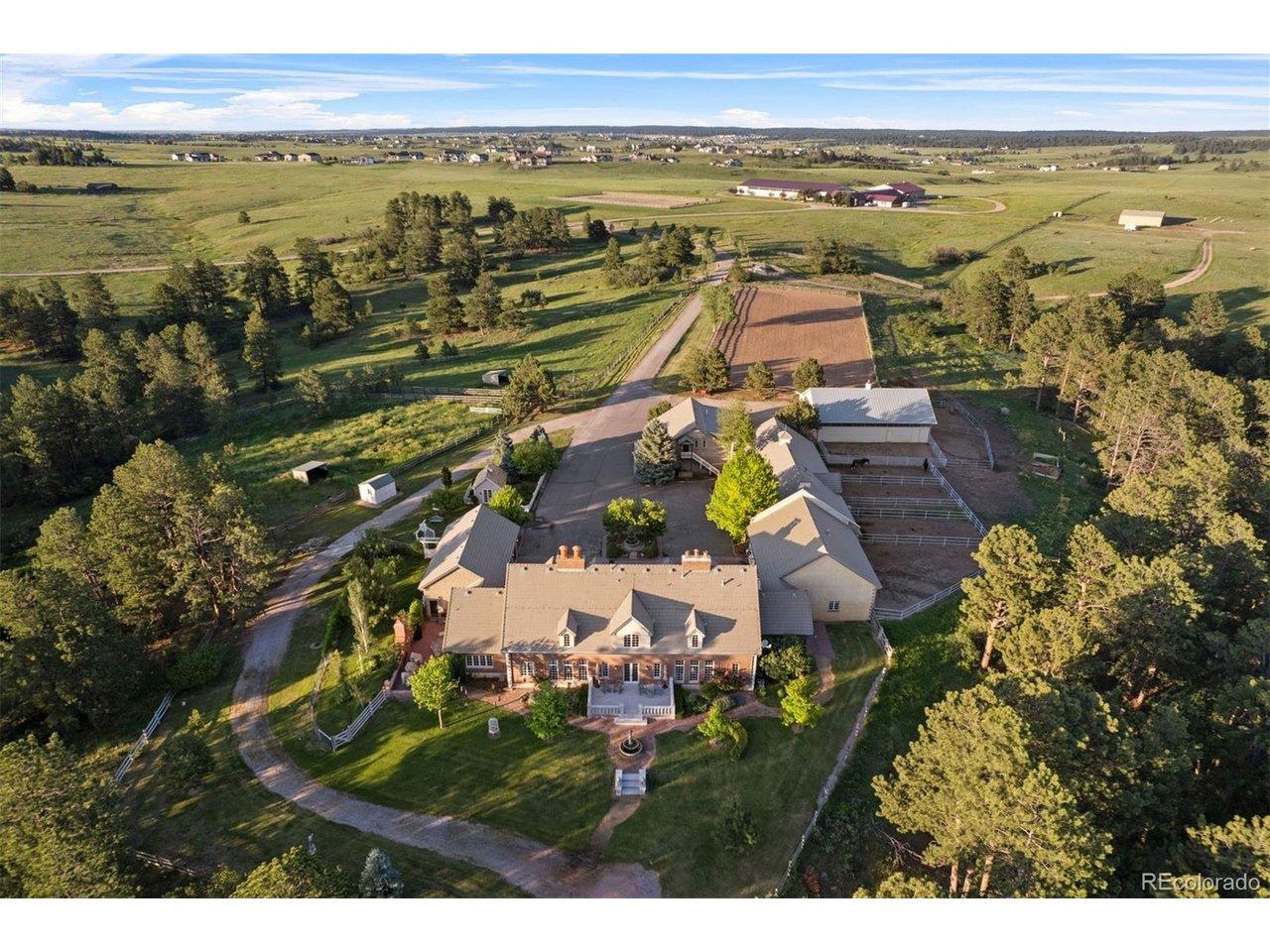 Image 4: From the rear elevation, Georgian symmetry meets open land, with terraces and gardens extending daily living into the surrounding meadows and trees.