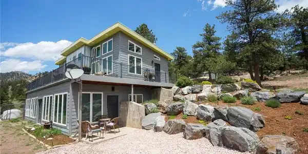 Image 4: Sunroom entry from lower level with Beautifully landscaped rock garden