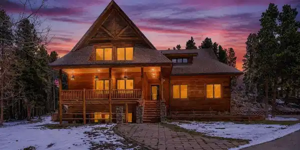 Image 2: Picture life here-an inviting mountain home at twilight, framed by towering pines and set on a rare, versatile lot with level usable space, easy access and room to relax, gather and truly enjoy the Colorado outdoors. Image 2: Picture life here-an inviting mountain home at twilight, framed by towering pines and set on a rare, versatile lot with level usable space, easy access and room to relax, gather and truly enjoy the Colorado outdoors.