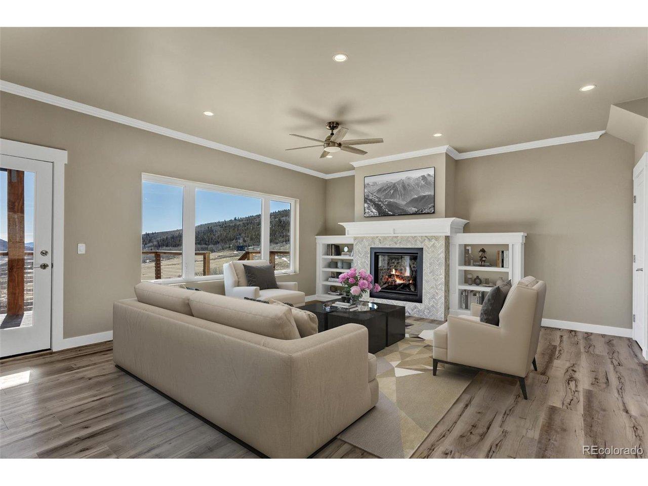 Image 4: Relax in style by the designer gas fireplace, complete with a custom herringbone tile surround and built-in shelving, all while the majestic peaks serve as your living wallpaper.