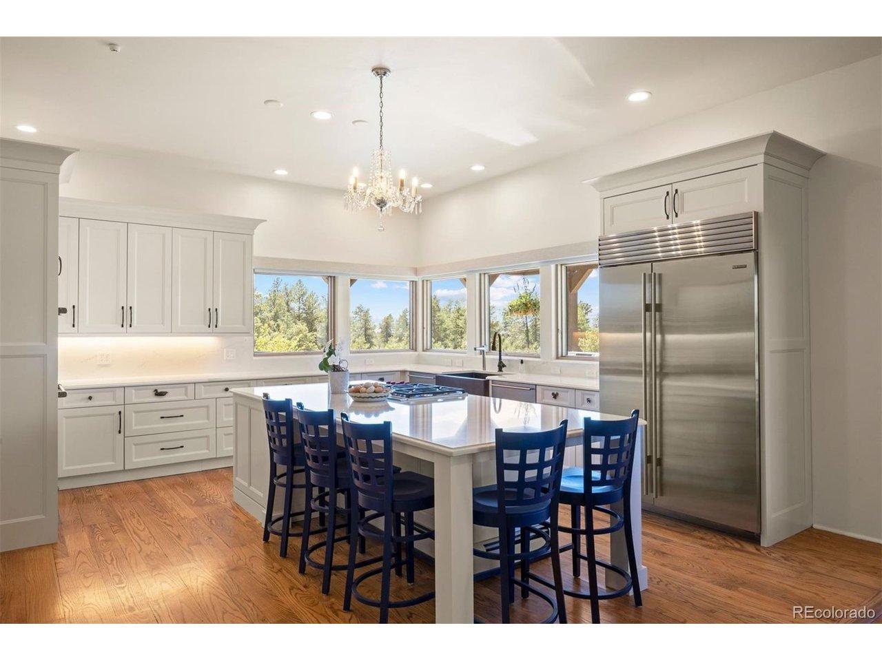 Image 3: The kitchen features Wolf and Sub-Zero appliances, an extra-large center island, quartz countertops, and white cabinetry. Image 3: The kitchen features Wolf and Sub-Zero appliances, an extra-large center island, quartz countertops, and white cabinetry.