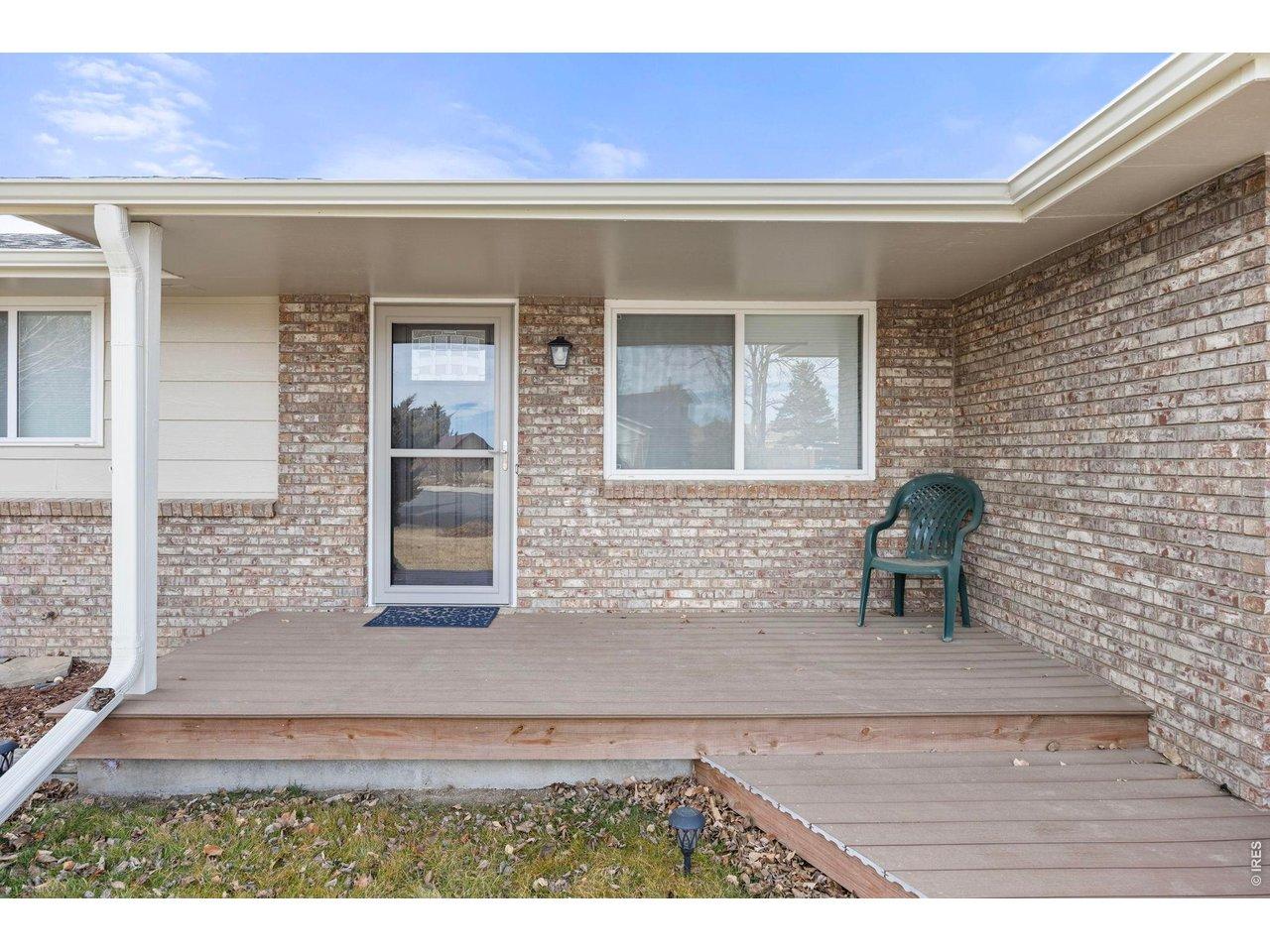 Image 4: The covered front porch welcomes you with a brand new wooden deck