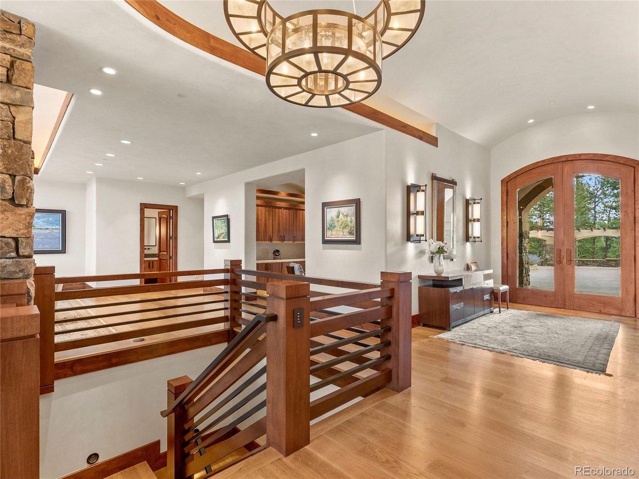 Image 4: The soaring foyer makes a striking first impression with its sweeping staircase, custom finishes, and designer lighting