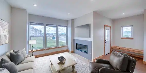 Image 3: Virtually staged living room with gas fireplace and mountain views