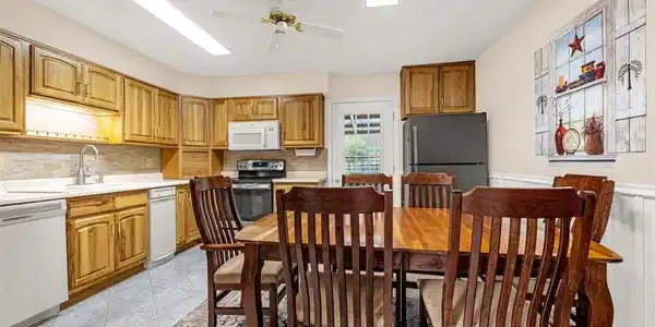 Image 2: Heart of the home the walk-out kitchen; tile flooring, wall of hickory cabinets, smooth counters, several lazy susans, appliance garage, pantry and ample room for larger table. Image 2: Heart of the home the walk-out kitchen; tile flooring, wall of hickory cabinets, smooth counters, several lazy susans, appliance garage, pantry and ample room for larger table.