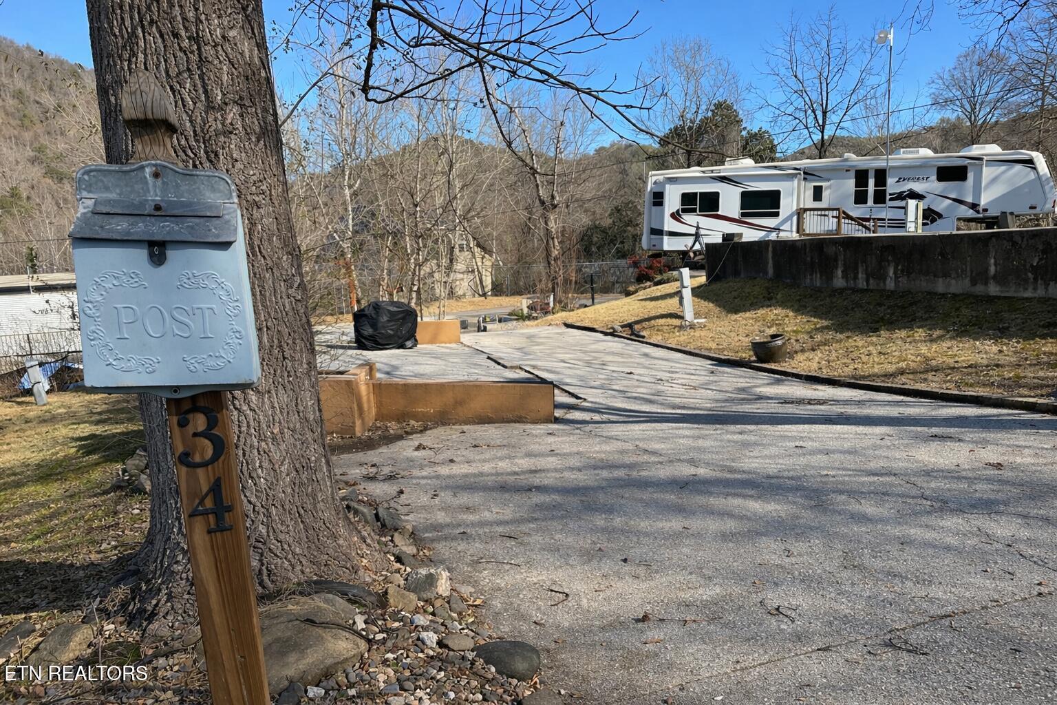 Image 3: Rustic mailbox by a sloping driveway