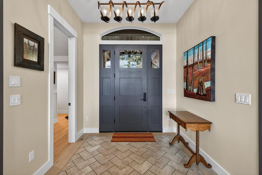 Image 4: Front Hall, With Herringbone tile and an arched window, it is a welcoming entrance to the is beautiful home.