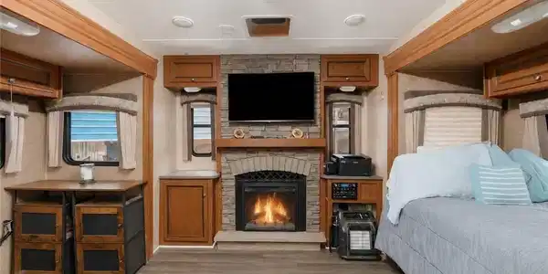 Image 4: Great Room, The great room for the Jaybird boasts a stone-clad fireplace with hearth, luxury-vinyl plank flooring, built-in cabinetry, recessed lighting, and multiple windows with blinds.
