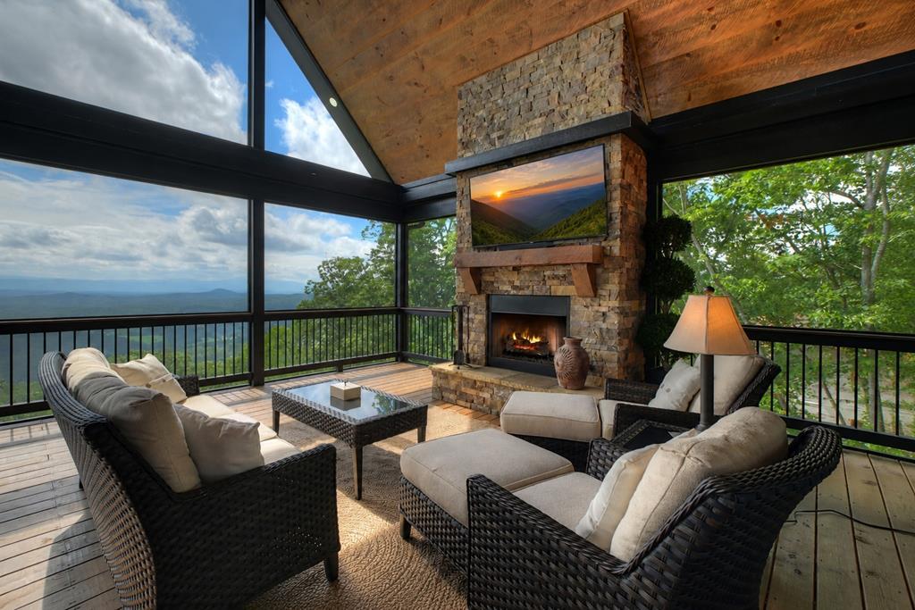 Image 4: Main level oversized back covered deck, Rock fireplace and screened in with year round views!