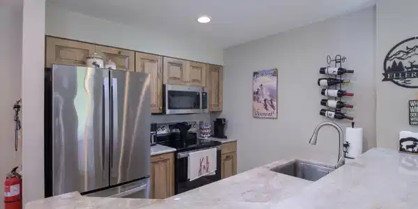 Image 4: Remodeled kitchen with wood cabinetry and tile floors