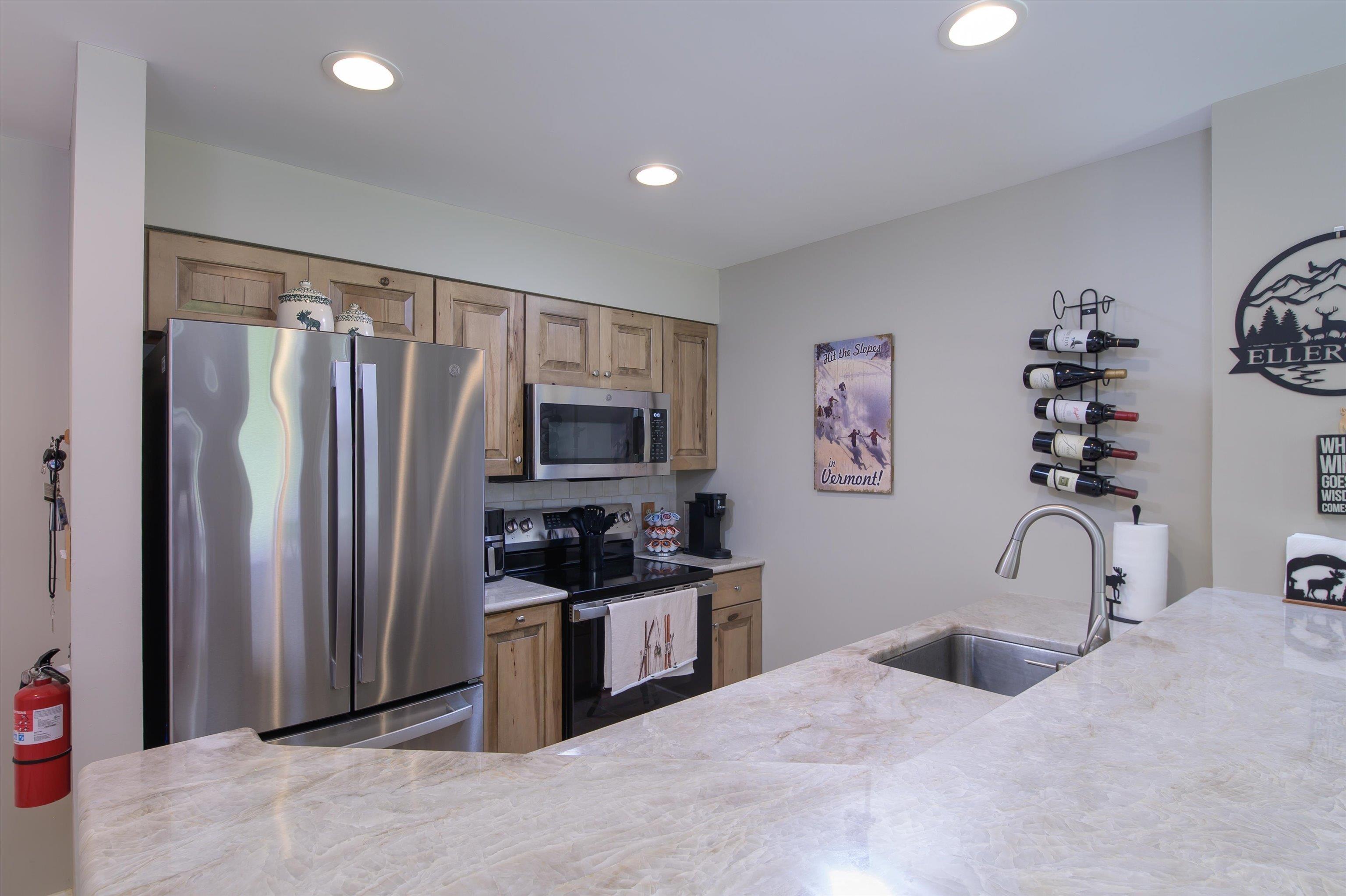Image 4: Remodeled kitchen with wood cabinetry and tile floors Image 4: Remodeled kitchen with wood cabinetry and tile floors