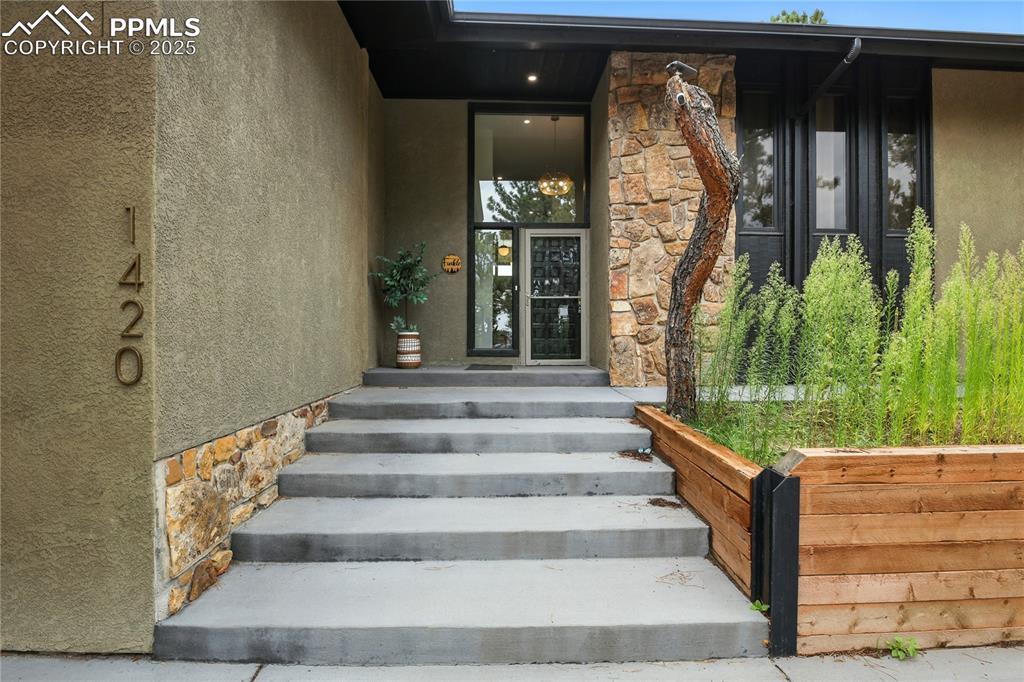 Image 2: Doorway to property with stone siding and stucco siding
