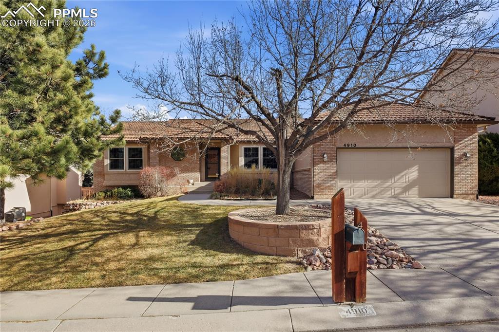 Image 1: Single story home with concrete driveway, a front lawn, an attached garage, brick siding, and a tiled roof