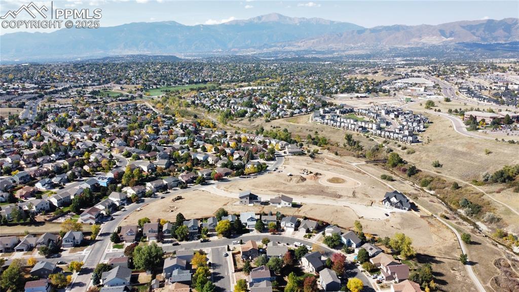 Image 2: Aerial view of property and surrounding area with nearby suburban area and a mountainous background