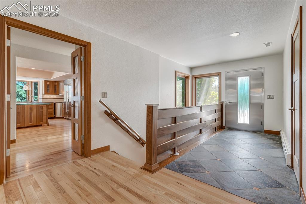 Image 3: Foyer entrance featuring light wood-style floors, a baseboard heating unit, a textured ceiling, and recessed lighting