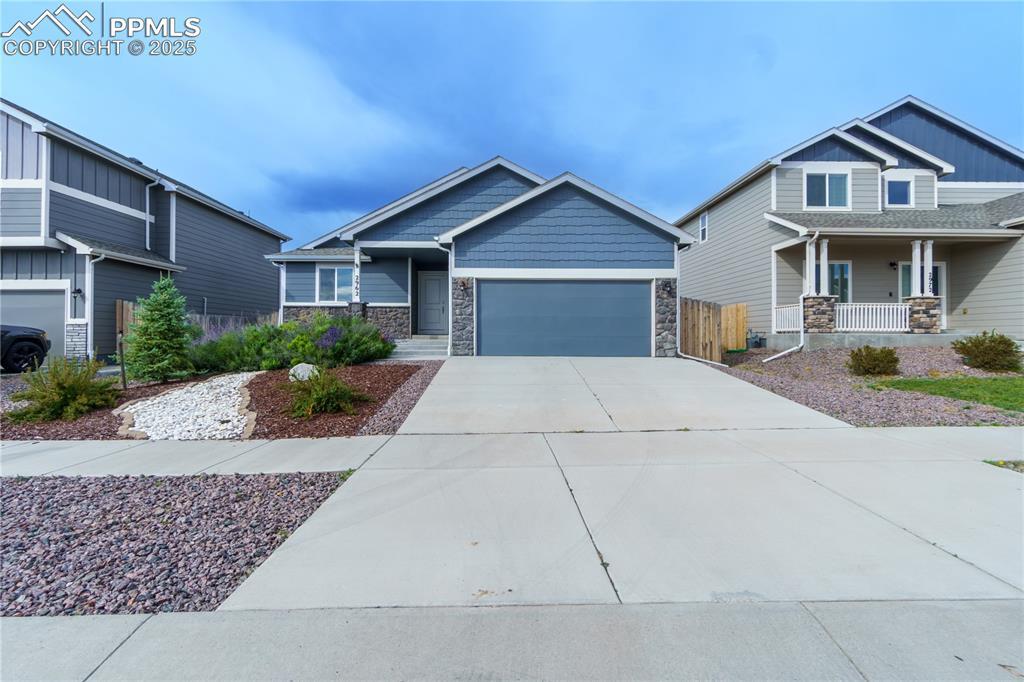 Image 1: Craftsman house featuring stone siding, driveway, and a garage
