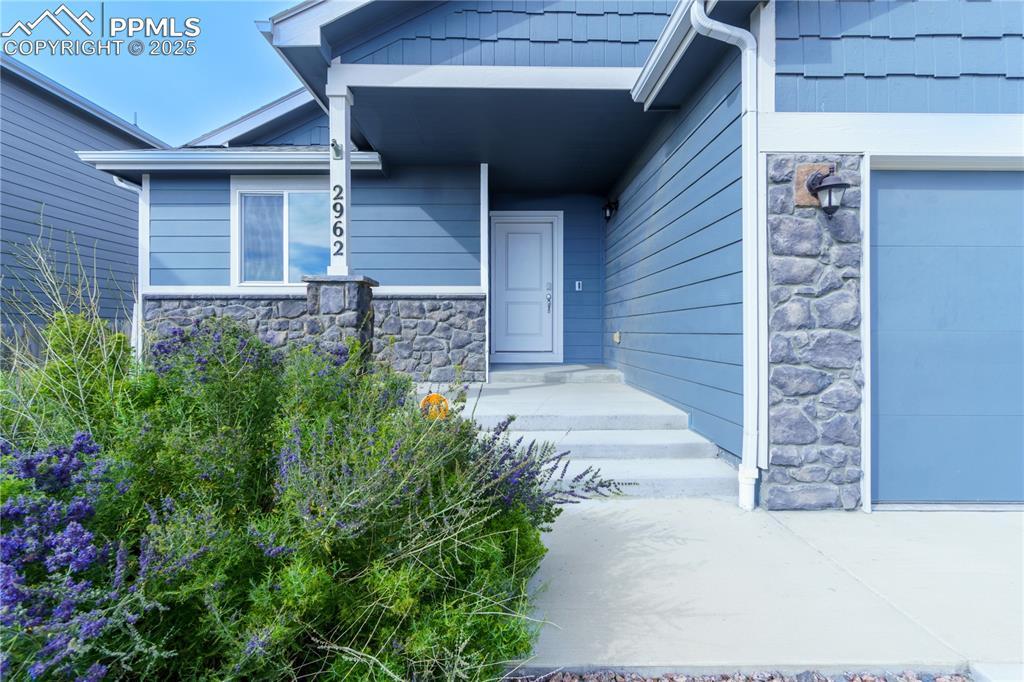 Image 4: Property entrance featuring stone siding