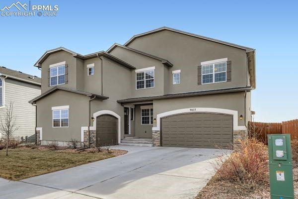 Image 2: Traditional home featuring an attached garage, stucco siding, and concrete driveway