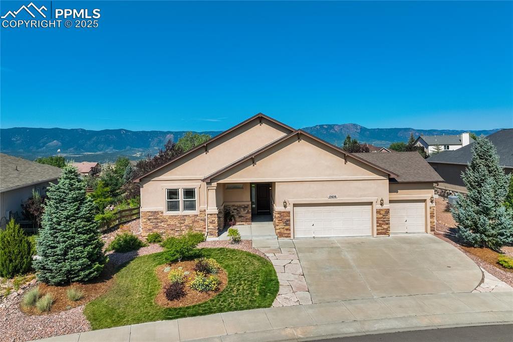 Image 1: Classic Colorado curb appeal with stucco + stone exterior, nestled on a premium lot backing to open space and walking trail.