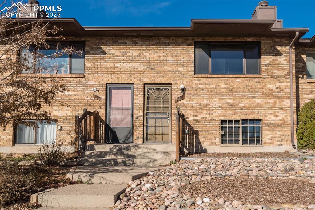 Image 2: View of front facade with a chimney and brick siding