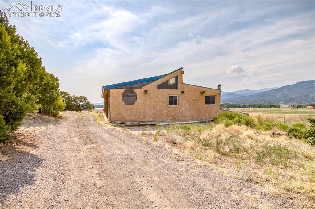 Image 2: View of home's exterior featuring stucco siding and a rural view