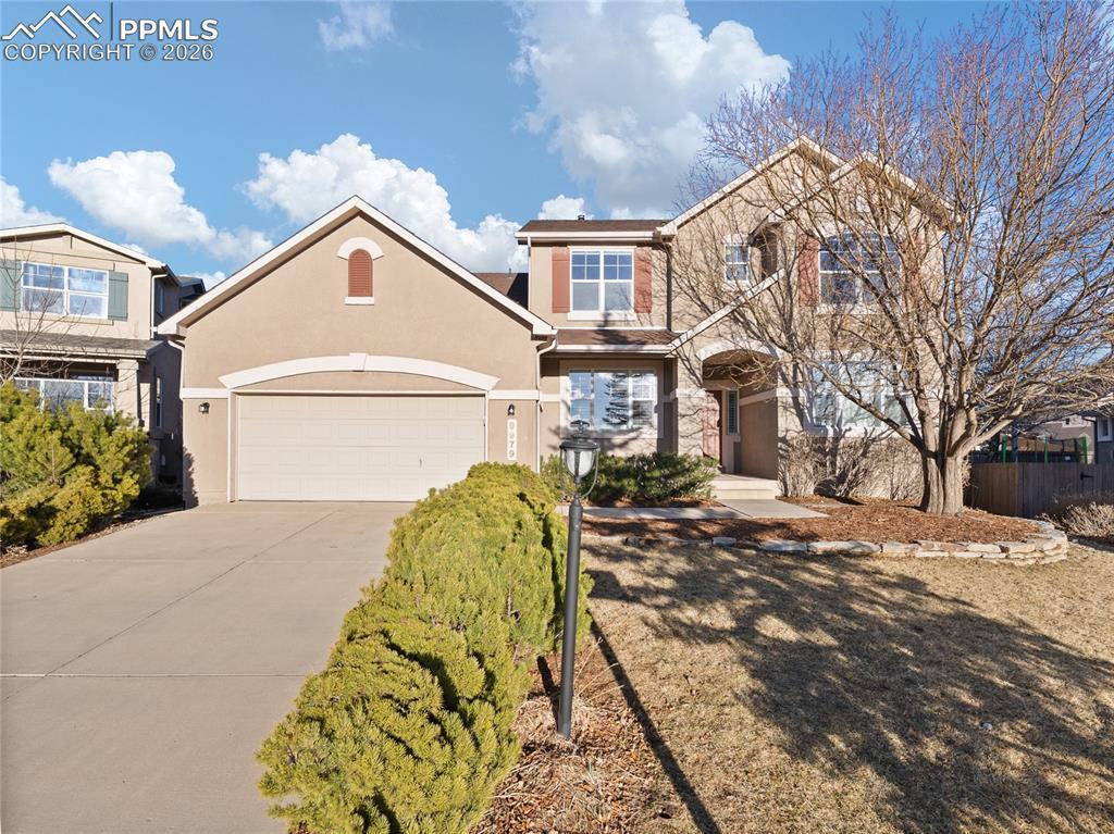 Image 1: Traditional home featuring concrete driveway, stucco siding, and stone siding