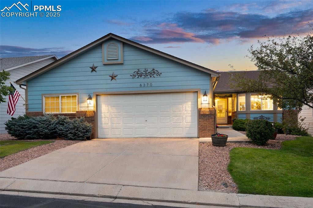 Image 2: Ranch-style house featuring brick siding, driveway, and a garage