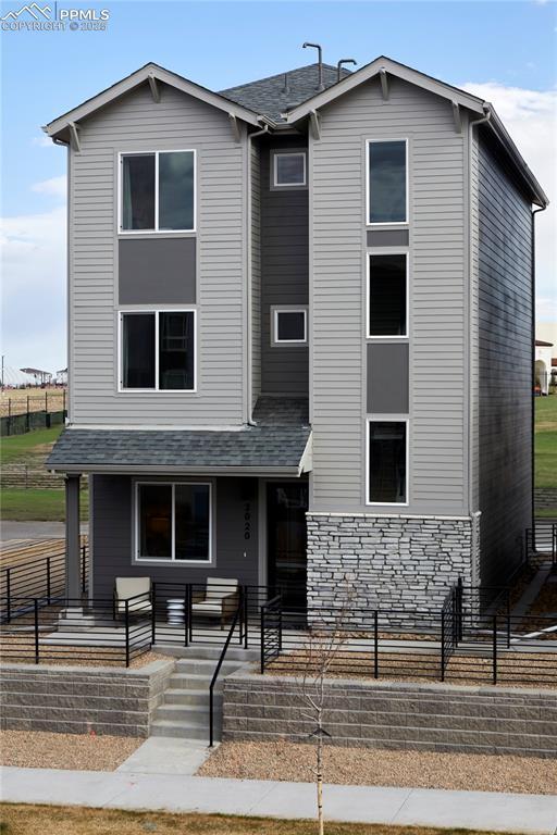 Image 1: View of front of house featuring covered porch and stone siding