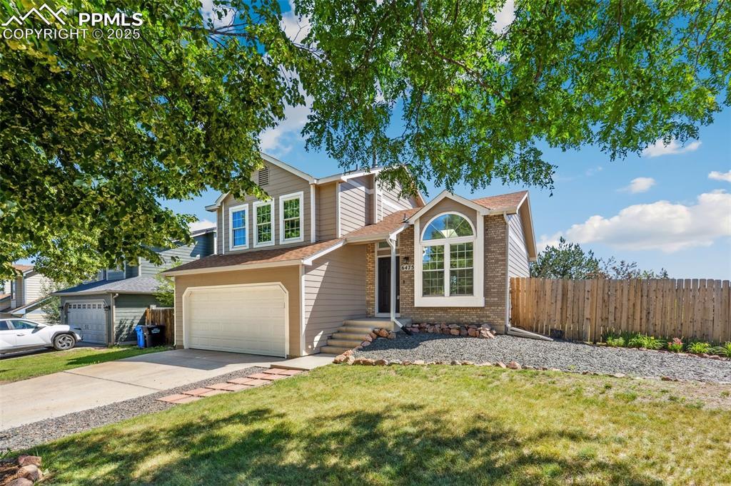 Image 2: Traditional home with an attached garage, driveway, brick siding, and a shingled roof