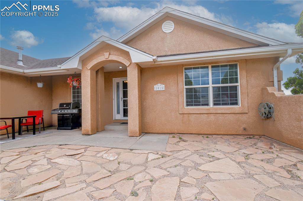 Image 2: Entrance to property featuring a patio area and stucco siding
