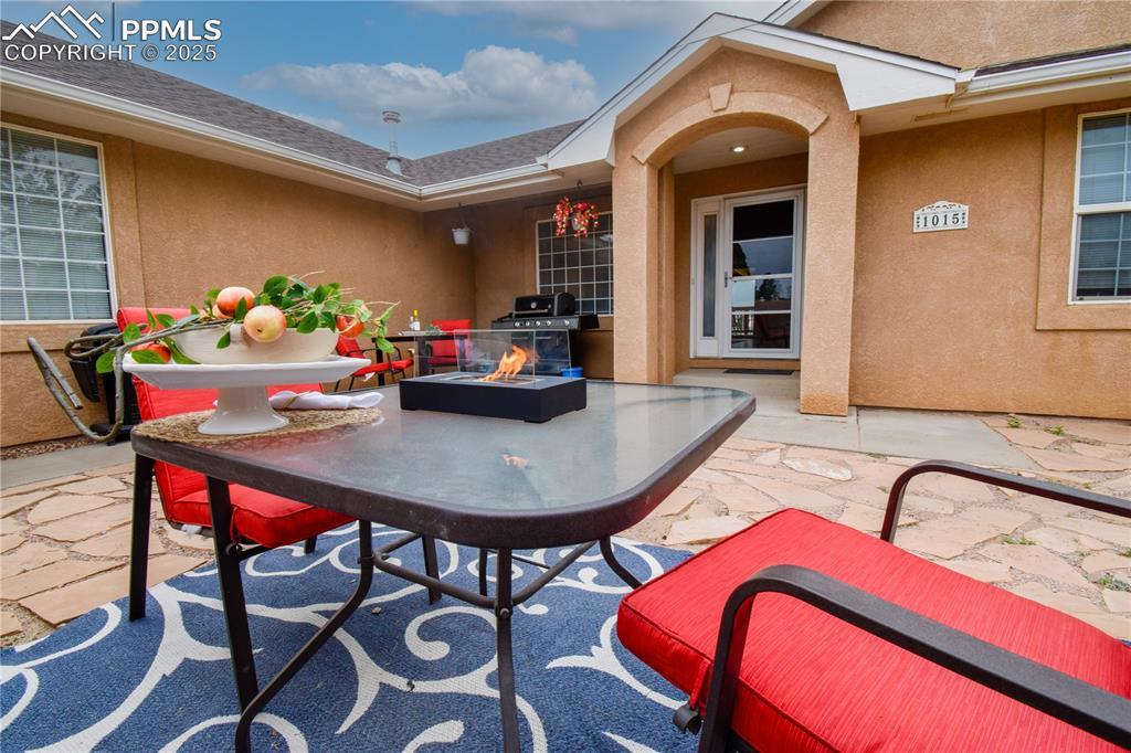 Image 3: View of patio featuring an outdoor fire pit and grilling area