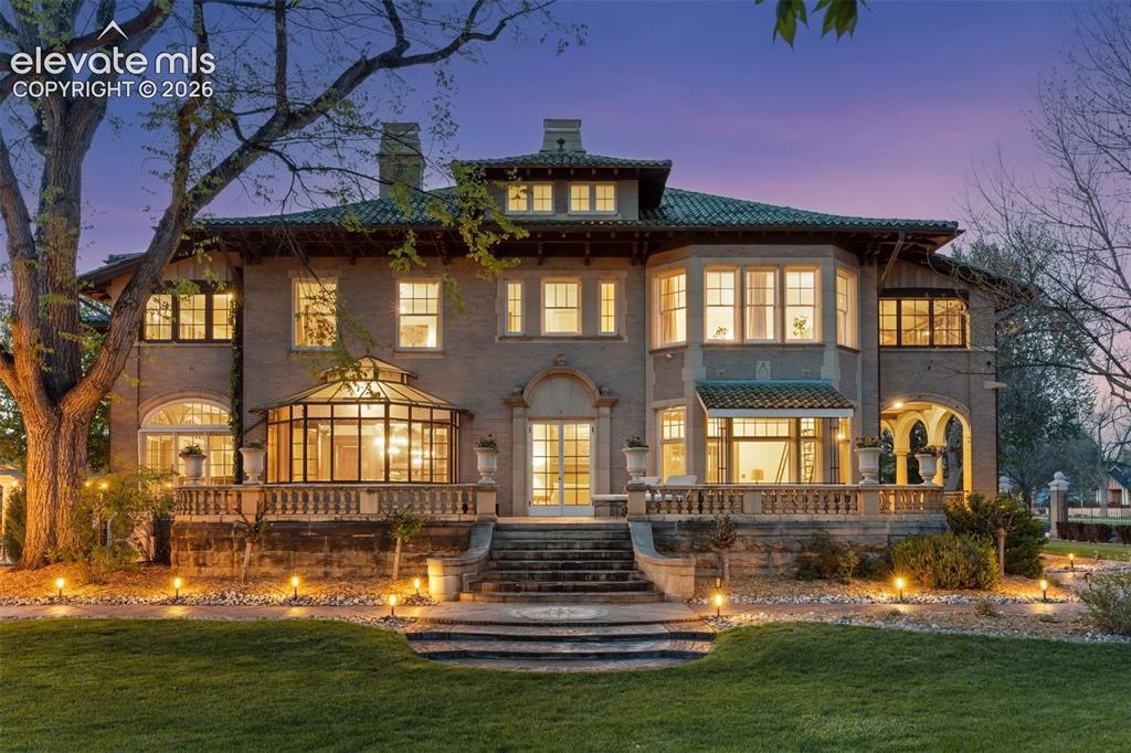 Image 2: Grand southern patio.  A spacious open porch overlooking the lawn&rsquo;s fountains and pergola, surrounded by a low balustraded stone railing.