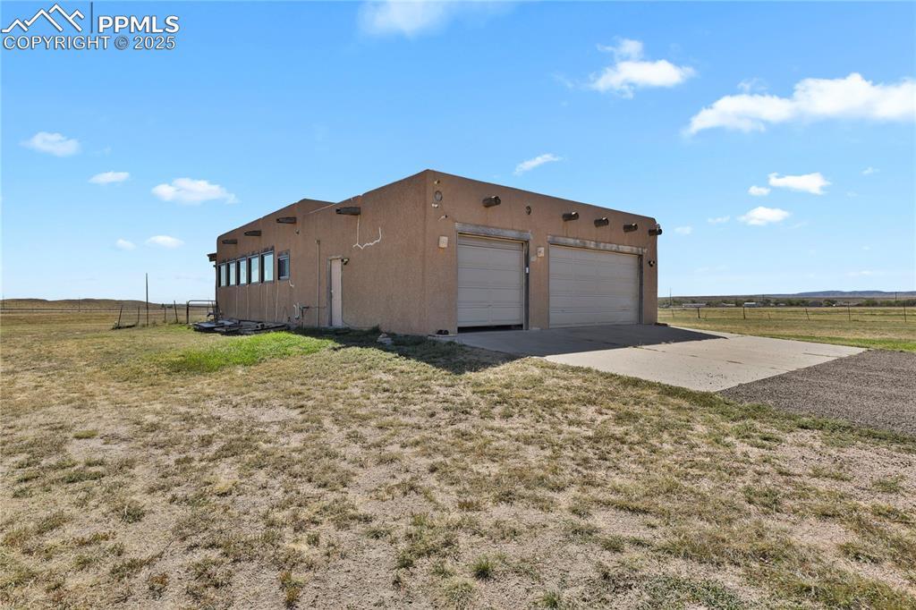 Image 3: View of side of home featuring a yard, a rural view, and a garage