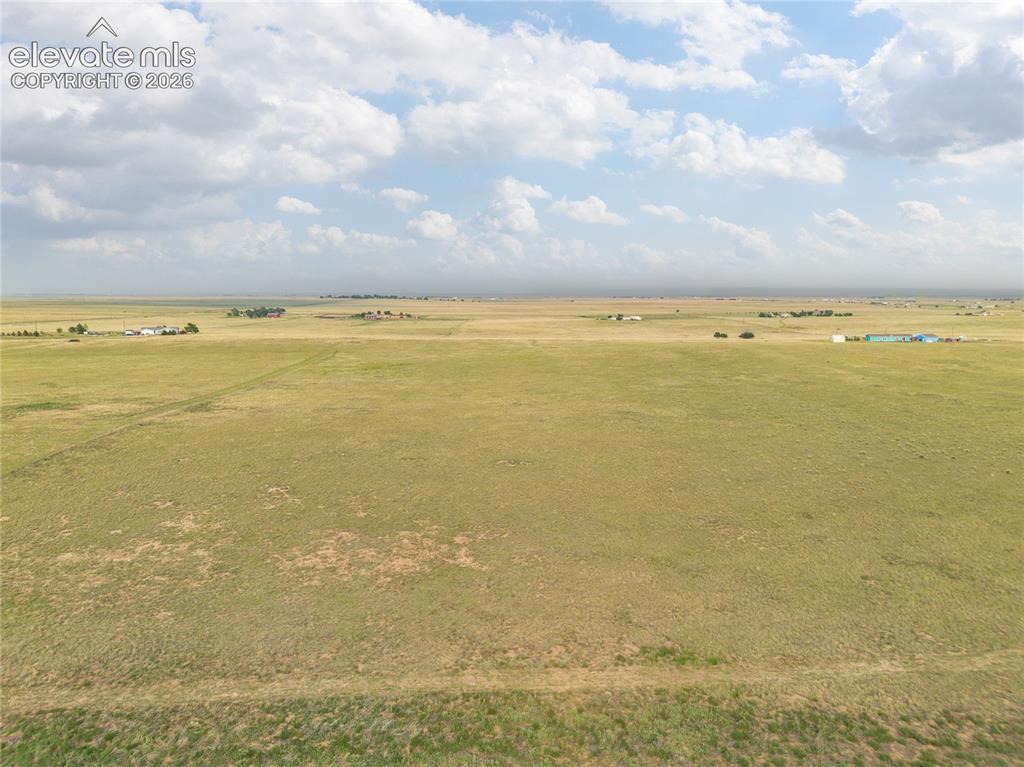 Image 4: Expansive open grassland under a partly cloudy sky